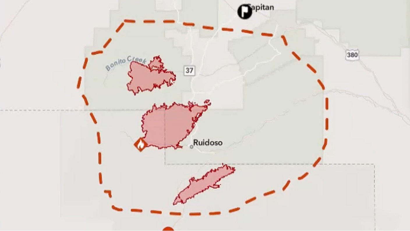 A map showing multiple wildfire perimeters outlined in red near Ruidoso, New Mexico, enclosed by a dashed orange boundary