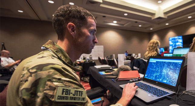 Person in combat uniform looking at a digital map