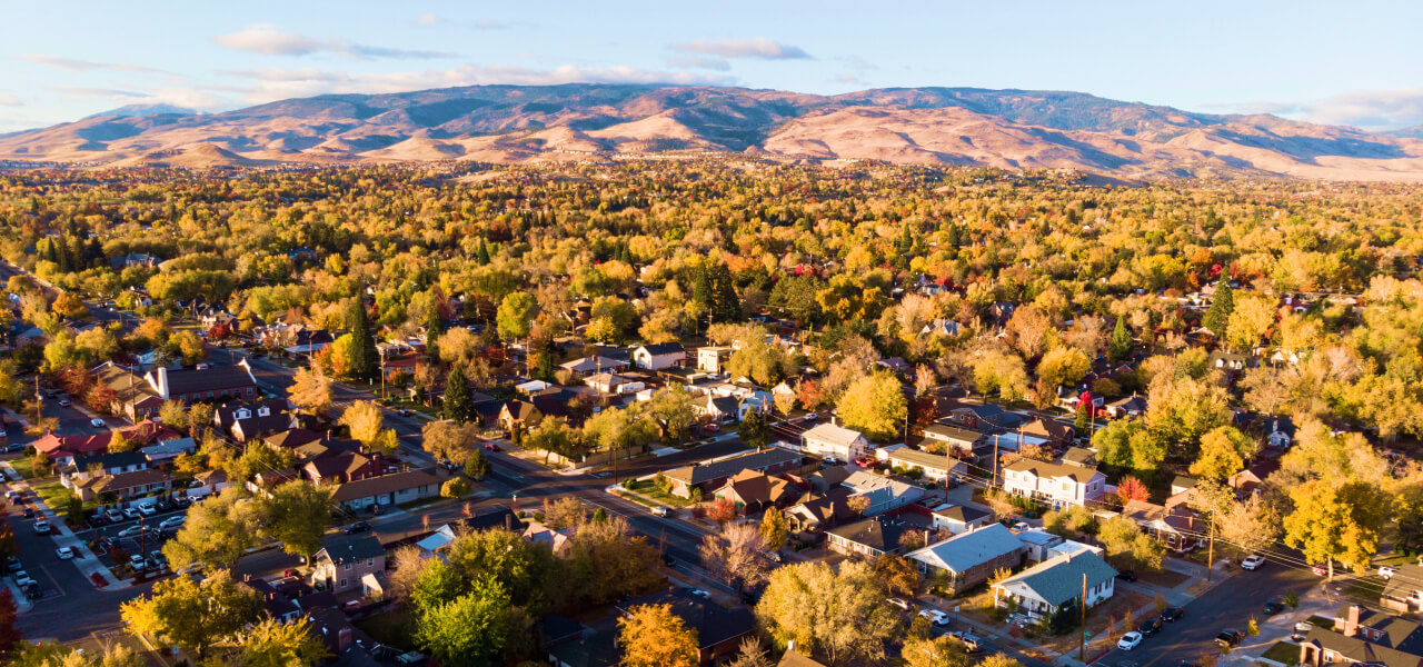 An aerial photo of a suburban neighborhood filled with autumn trees in orange and yellow