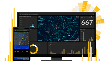 Monitor desktop che mostra una dashboard con grafici e una mappa scura con punti di interesse contrassegnati in rosso, giallo e blu e un telefono cellulare con una mappa scura
