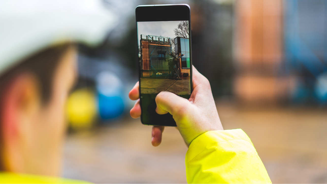 Person taking a photo of a building with a cell phone