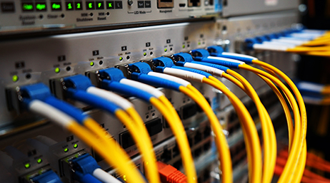 Primer plano de los conectores azules de telecomunicaciones con cables amarillos enchufados a una placa base