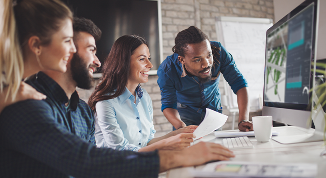 Four people looking at a computer monitor