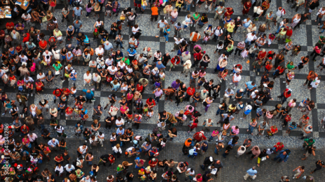Overhead view of a crowd of people standing in a city center 