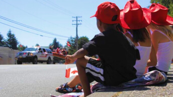 Children holding a Canadian flag during a parade