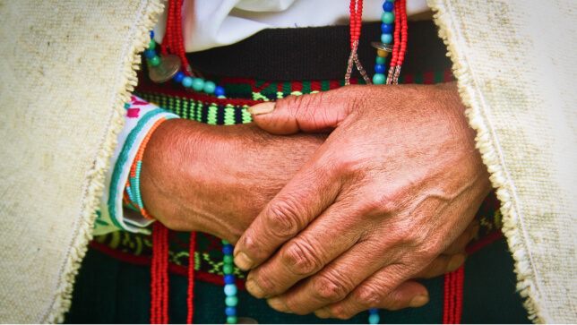 Persona tribal con sus manos cruzadas 