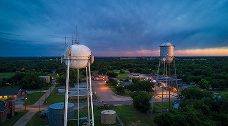 Two water towers below a cloudy sky