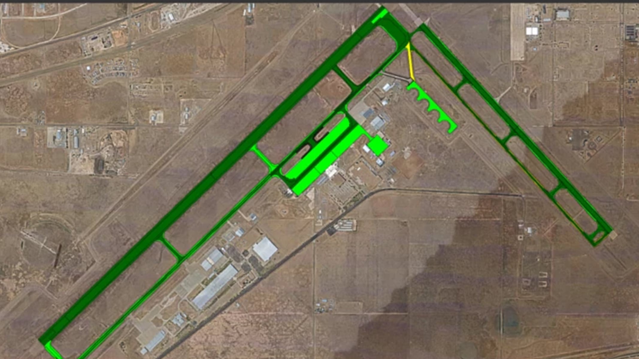 Aerial view of an airfield with structures such as buildings and fencing displayed in green