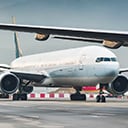 A large commercial airplane is shown taxiing on an airport runway. 