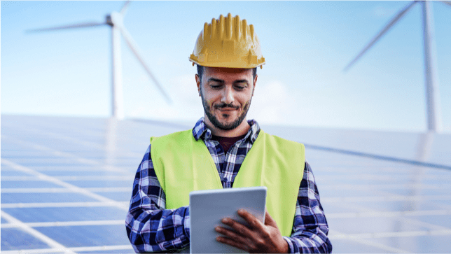Man in a hardhat with windmills behind him