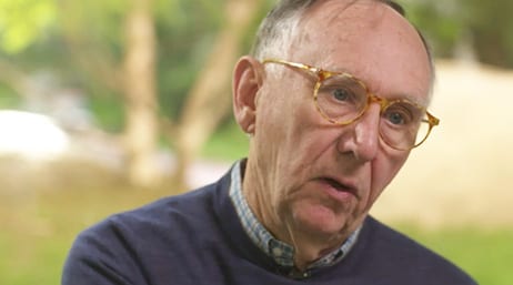 A screencap from the featured video, with Jack Dangermond in mid-speech wearing a dark blue sweater with a soft-focus sunlit meadow in the background