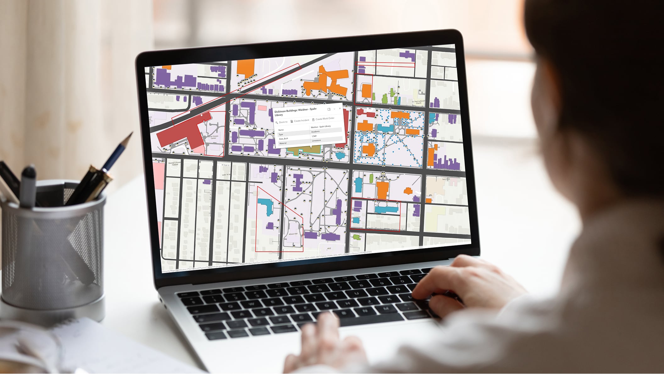 A person typing at a laptop displaying an interactive street map
