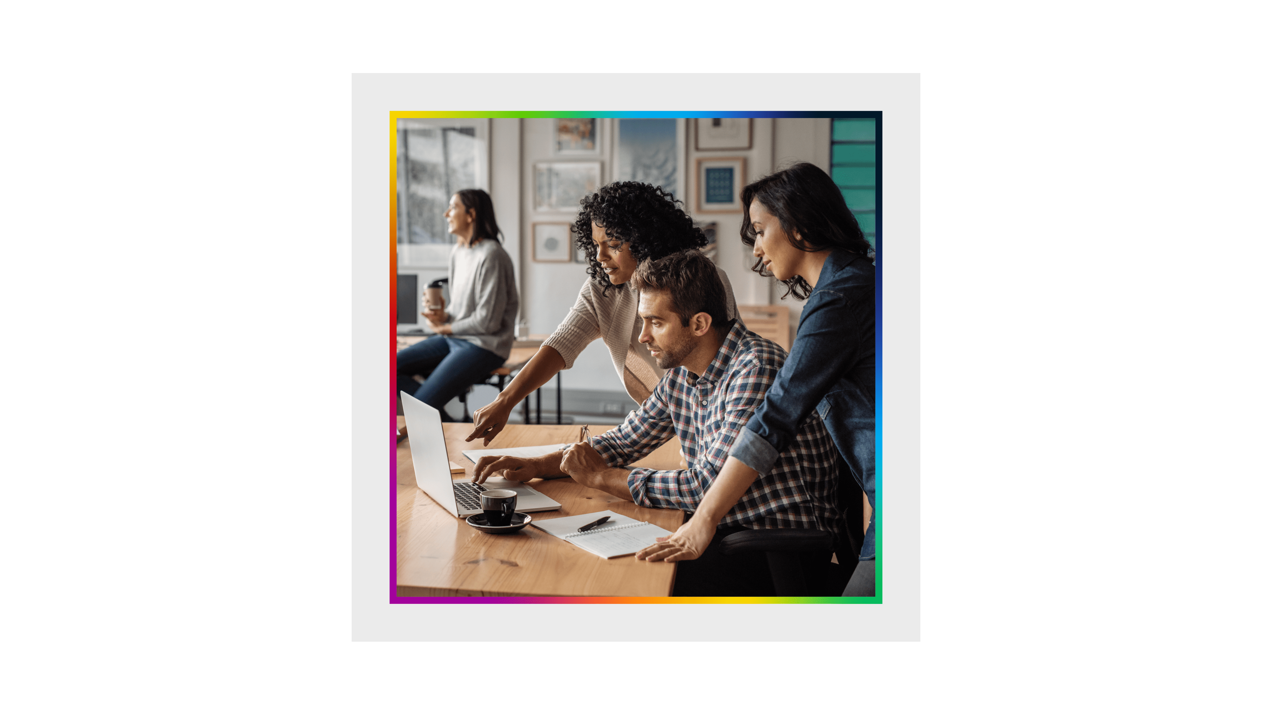 Three colleagues working together at a laptop