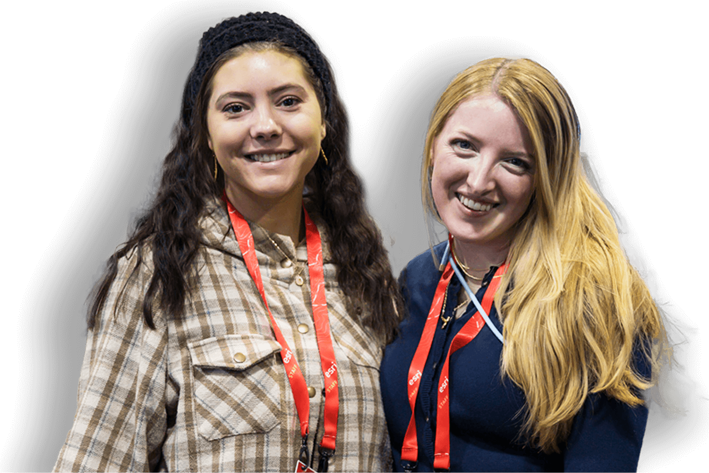 Two people wearing conference lanyards standing together and smiling