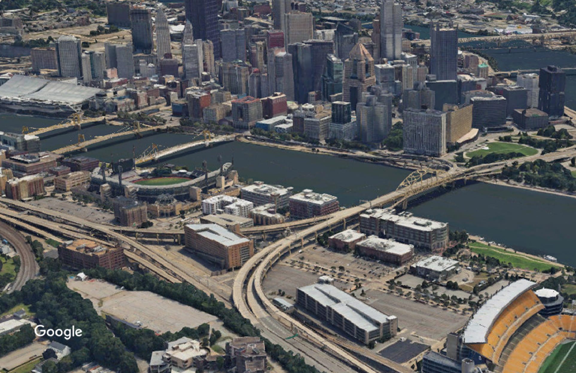 An aerial view of Pittsburgh, Pennsylvania, including the skyline, rivers, bridges, and football stadium