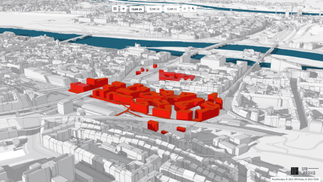 A black and white 3D map of a city features a cluster of buildings in bright red, indicating an area of interest.