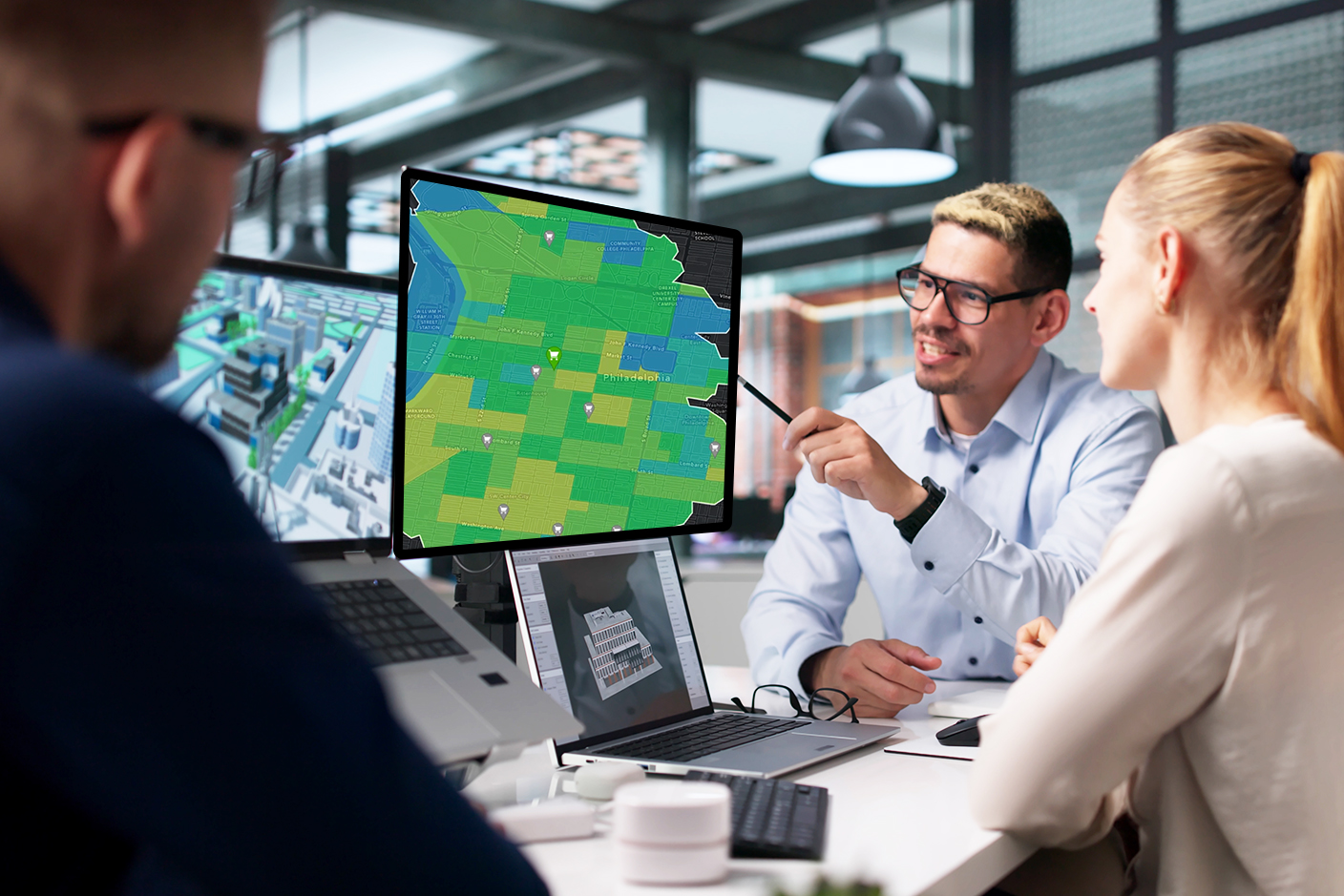 Business and government professionals looking at a parcel map on a monitor.
