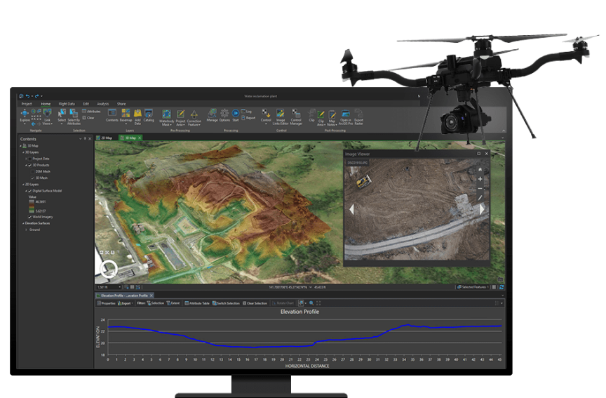 A flying black drone next to a computer monitor showing a digital image of terrain with green land and brown hills