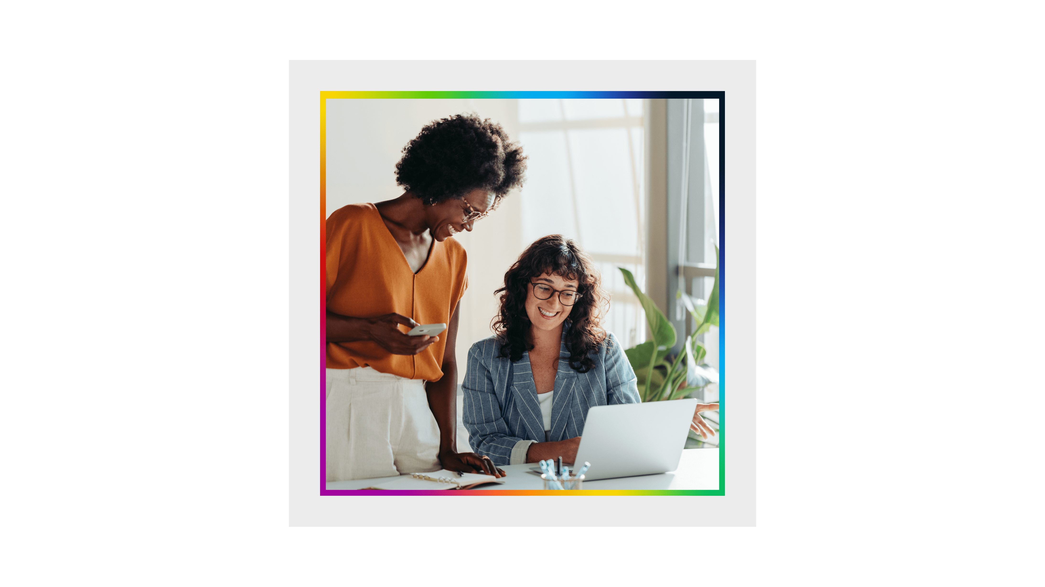 A faint grey and white map overlayed with two women collaborating at a laptop and smiling