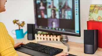 A person smiling while on a video call on a desktop computer