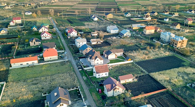 An aerial photo of a residential neighborhood with fields and houses