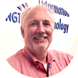 Thomas Konzel in an orange collared shirt in front of a sign for the City of Arlington information technology department