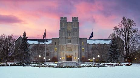 A view of a Virginia Tech building with pink and purple clouds in the background