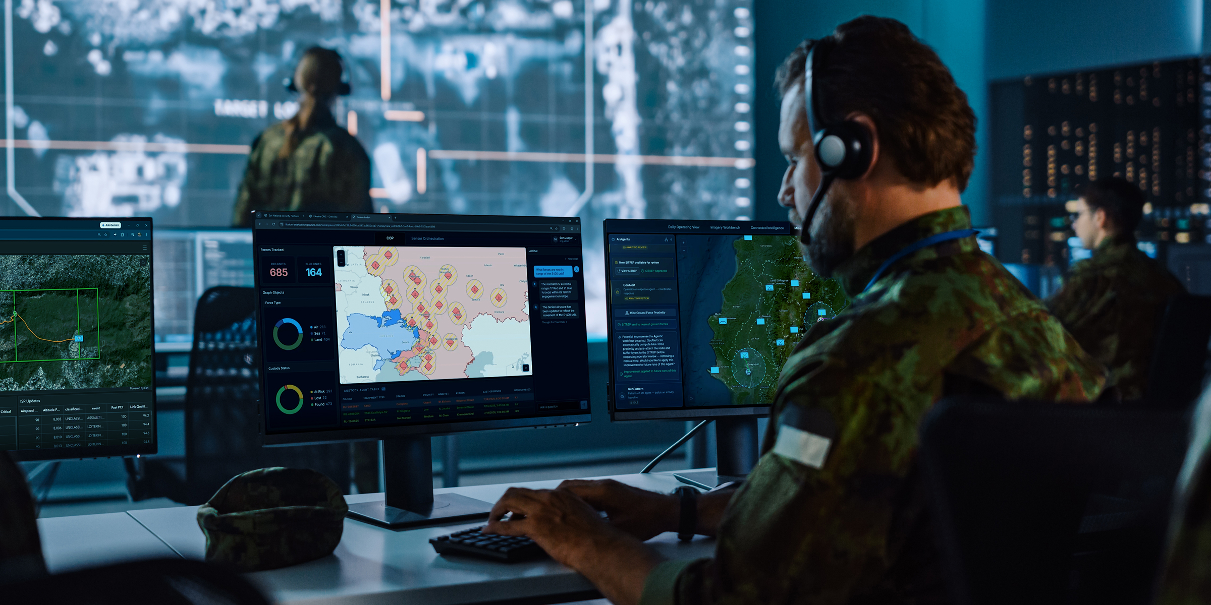 Command center with military personnel working at computers that face a large map