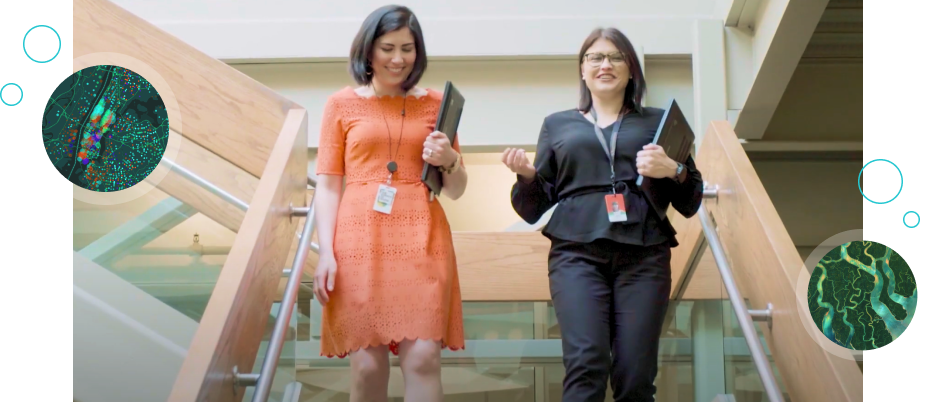 Two Esri employees—one named Marcella—talking and walking down the stairs in Esri Headquarters