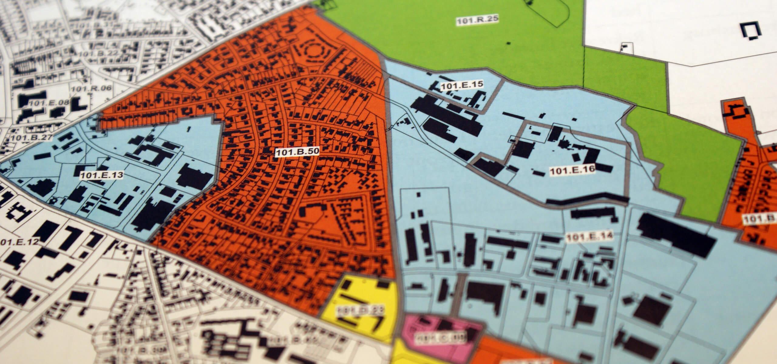 A city map showing individual building plots with regions shaded blue, green, and orange