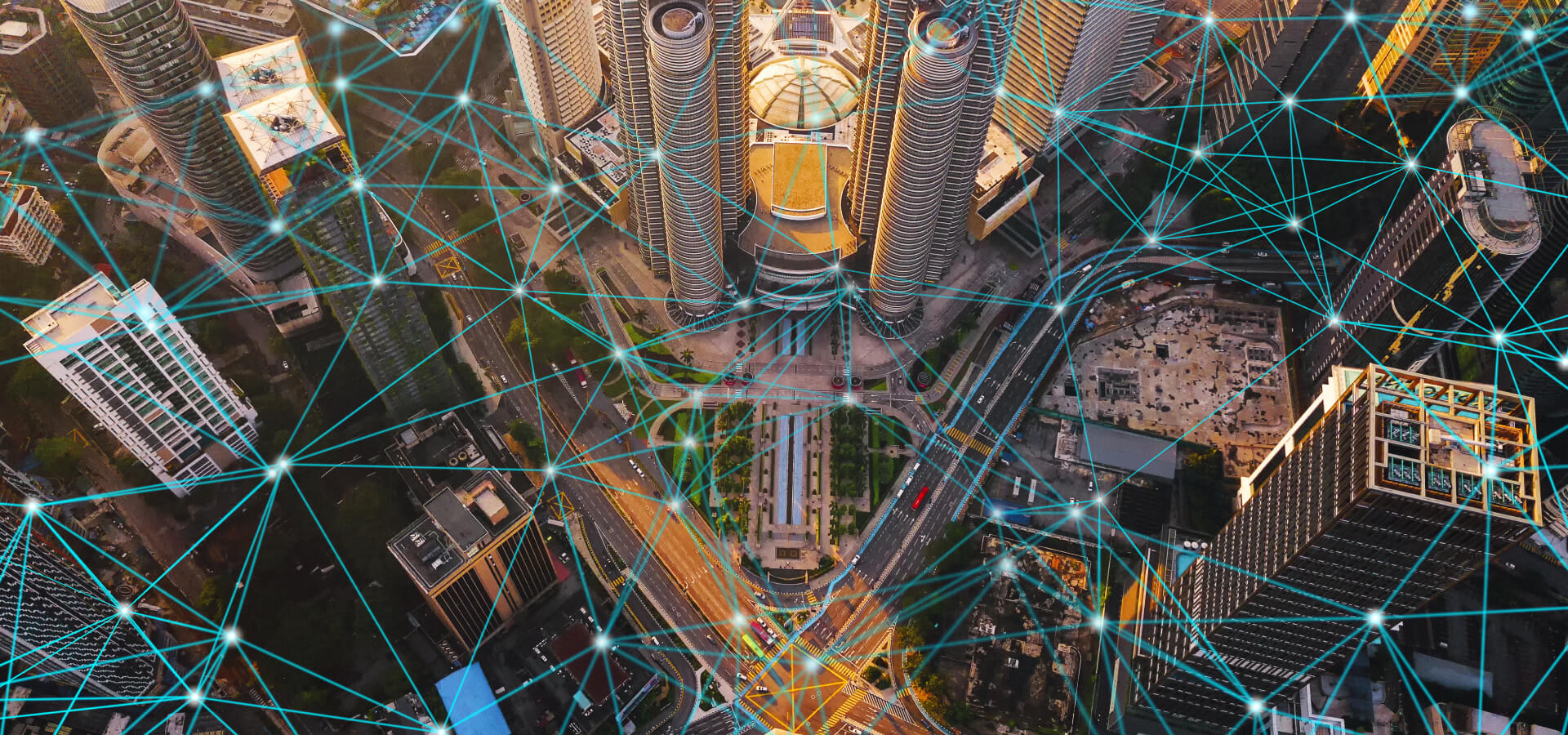 An aerial view of a dense modern city overlaid with a bright blue web of connected points