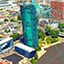 A 3D model of modern buildings near a river, with turquoise lines attaching the top of one building to another across the river