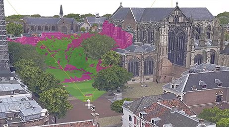 A 3D mesh of a gothic church and surrounding grounds overlaid with a play button
