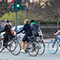 A group of cyclists in winter clothing crossing an intersection on bikes