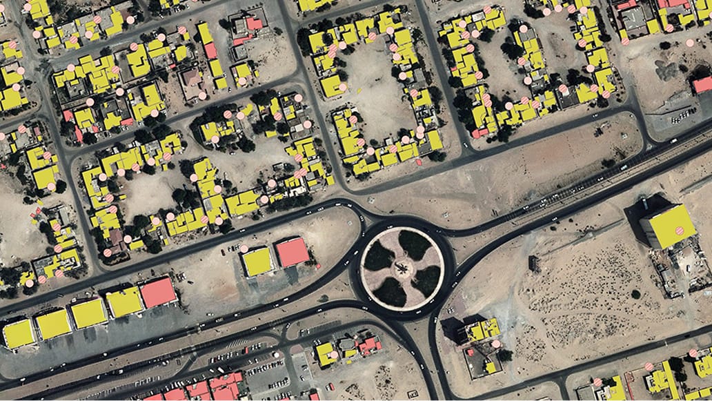 This image shows a top-down aerial perspective of a suburban neighborhood featuring a prominent roundabout at the center. 