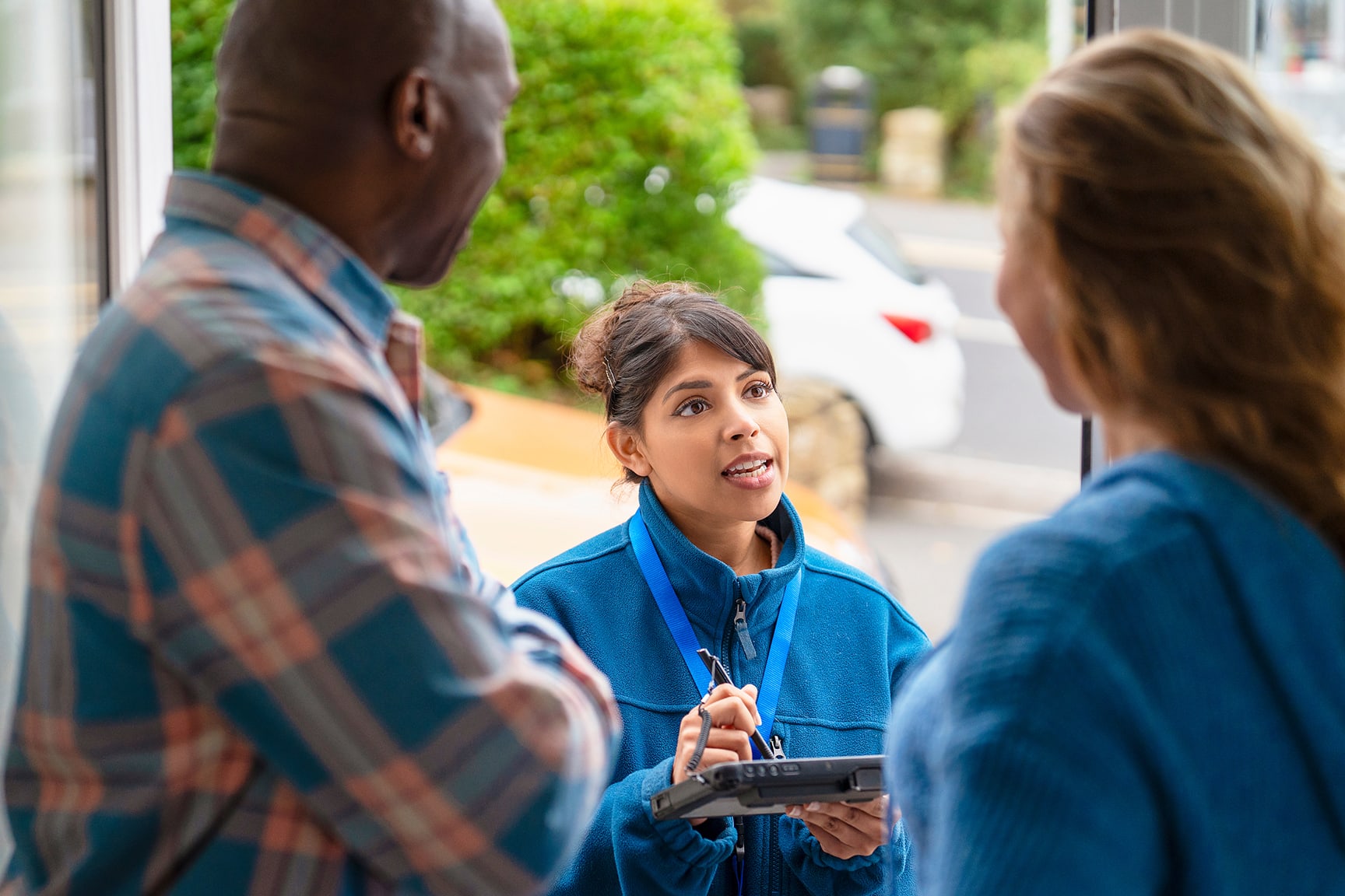 A census worker speaking with residents outside a home.