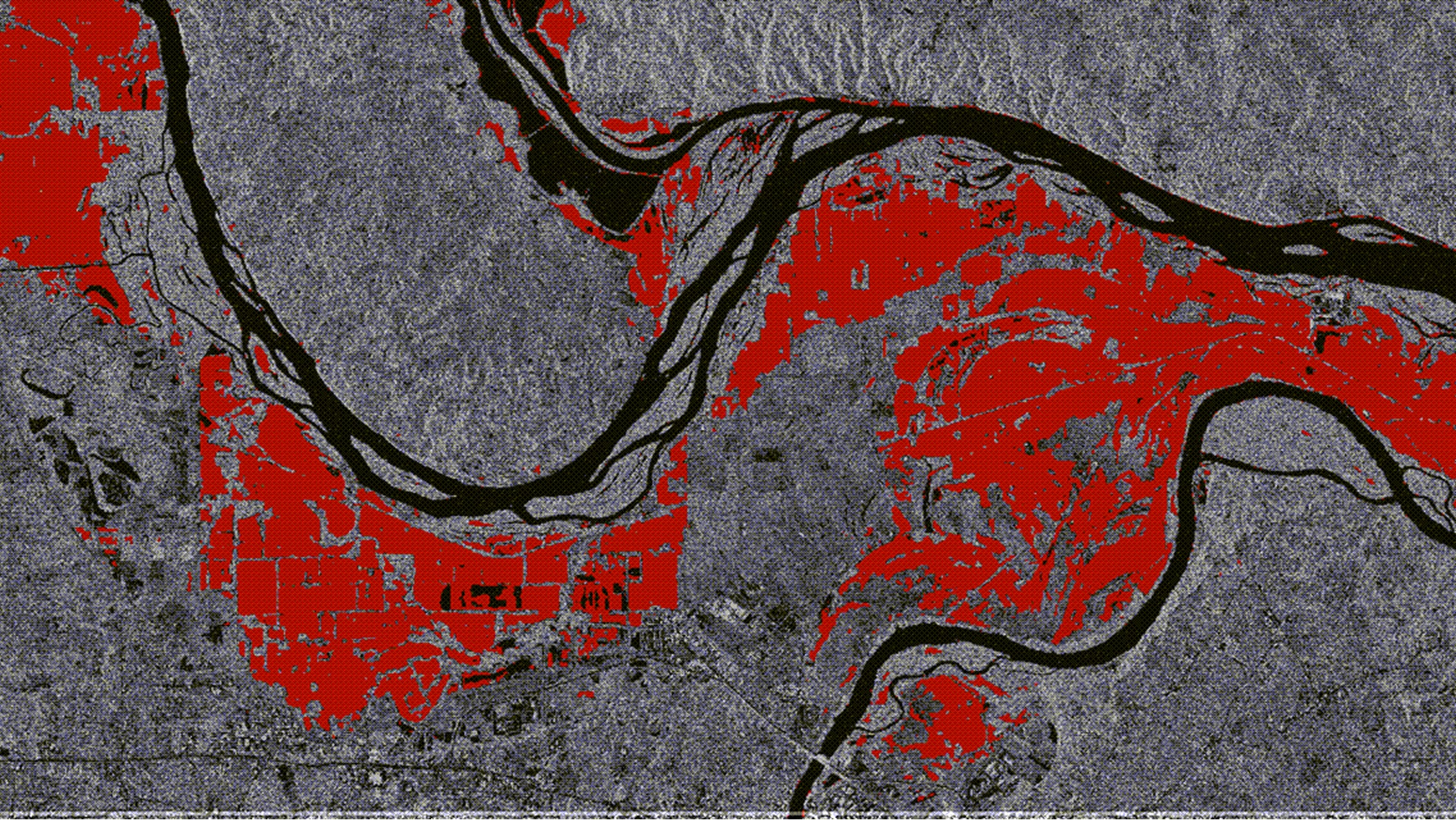 Remote sensing analysis highlighting flood extent or land cover changes in red near river channels