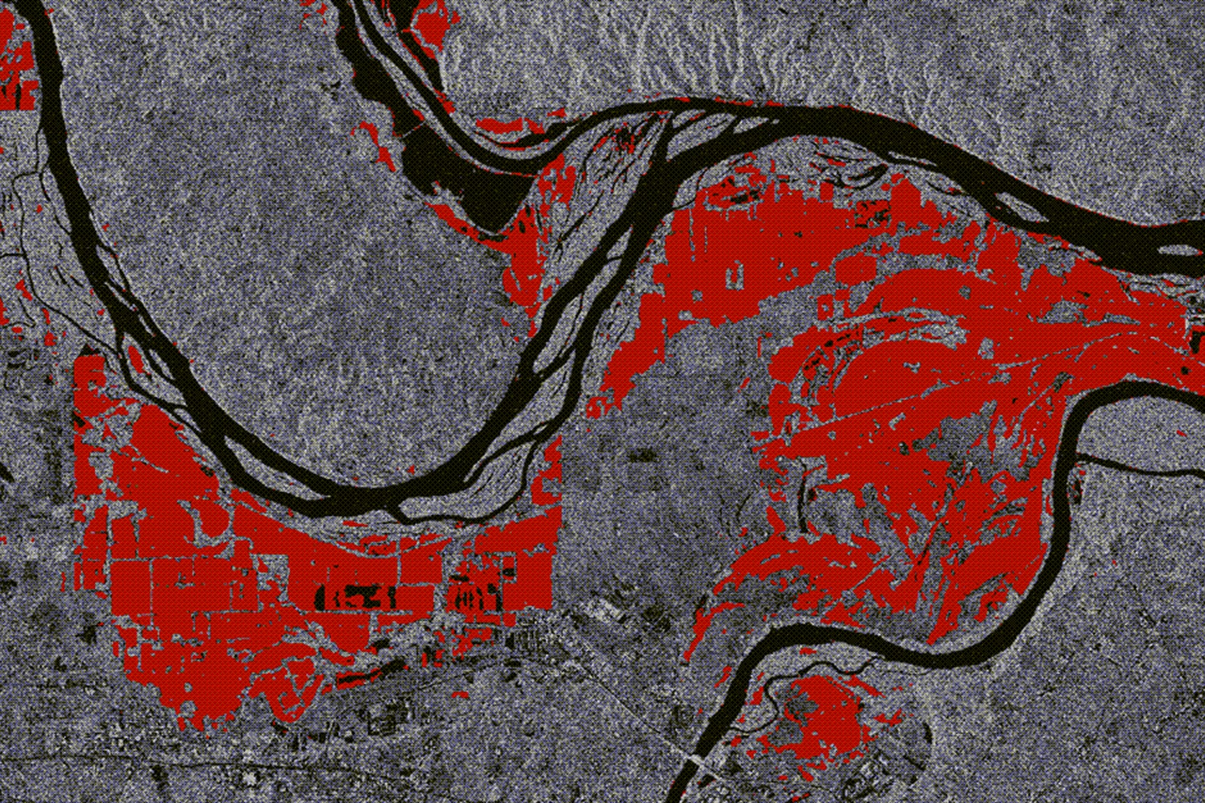 Remote sensing analysis highlighting flood extent or land cover changes in red near river channels