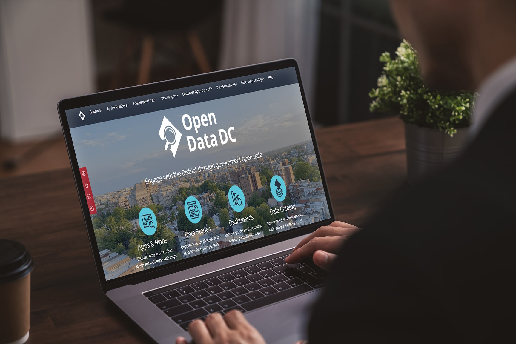 A person works on a laptop displaying the Open Data DC website