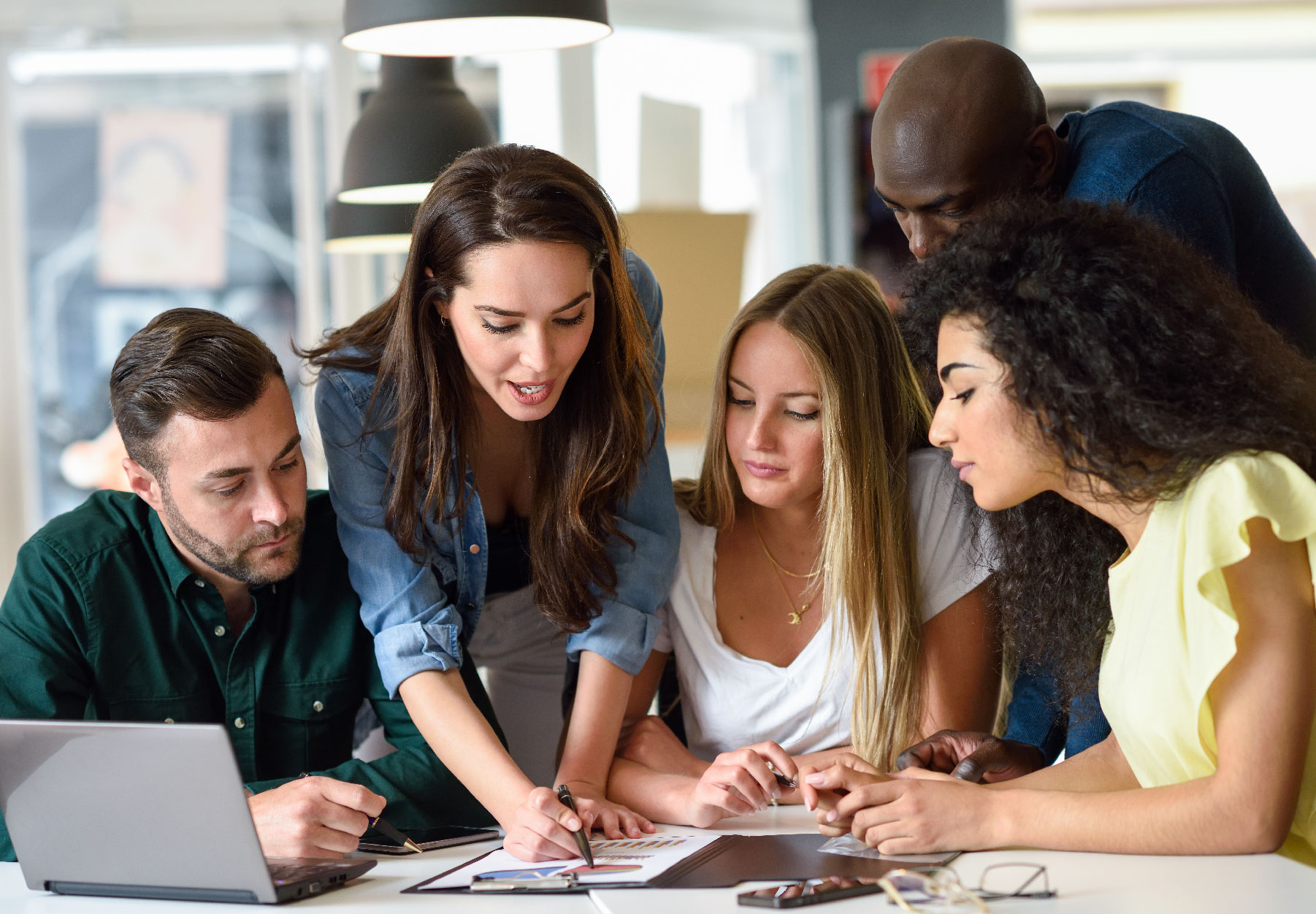 Higher education students working together at a desk with computer.