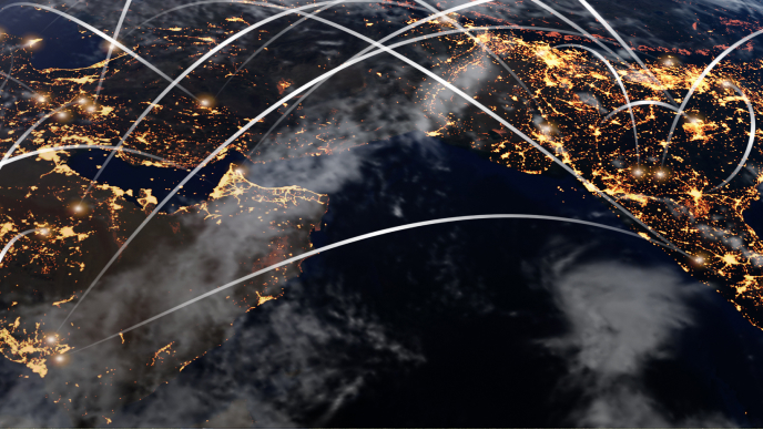 Satellite-style view of Earth at night shows illuminated cities across continents