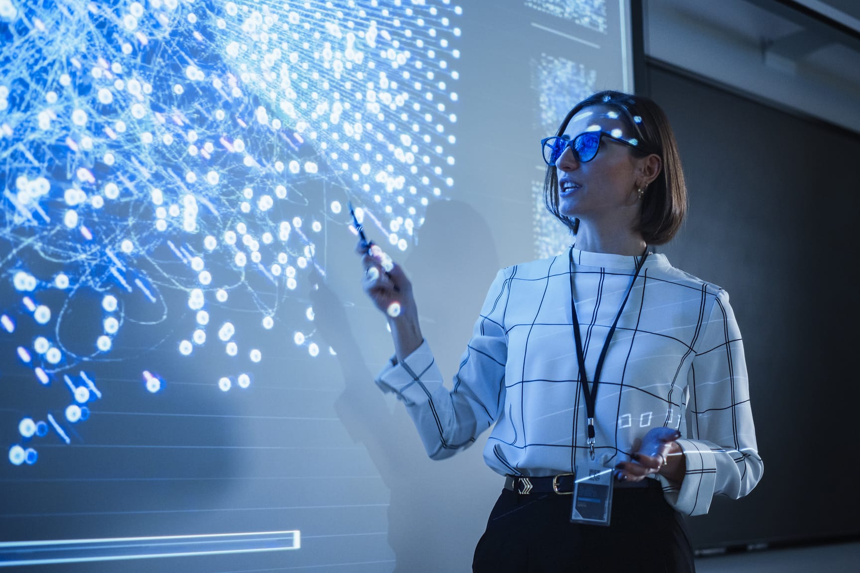 Image of a female pointing at a white board with data points on it.