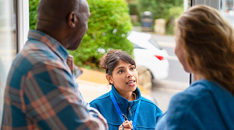 A field worker talking to residents at their door step 