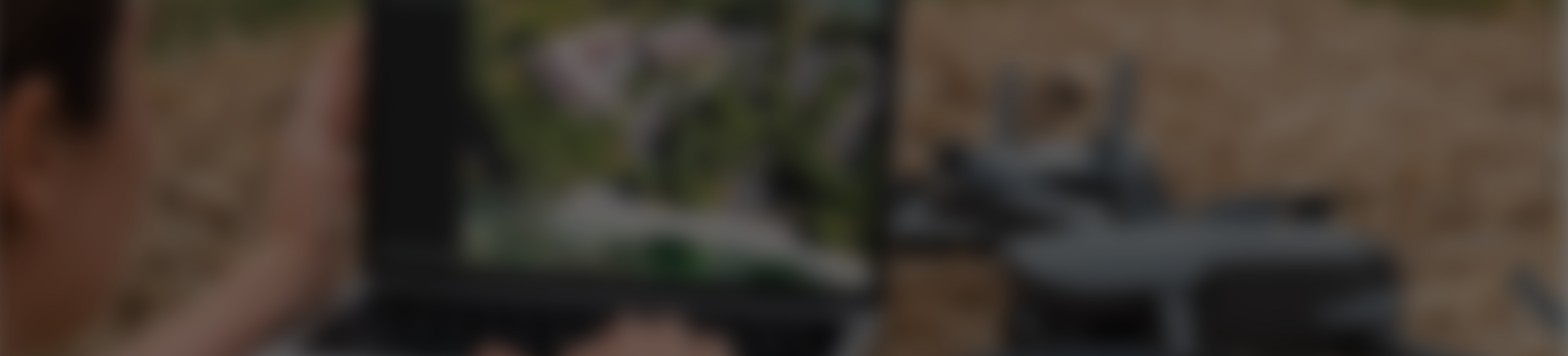 A student in a field next to a drone using a laptop with map image displayed.