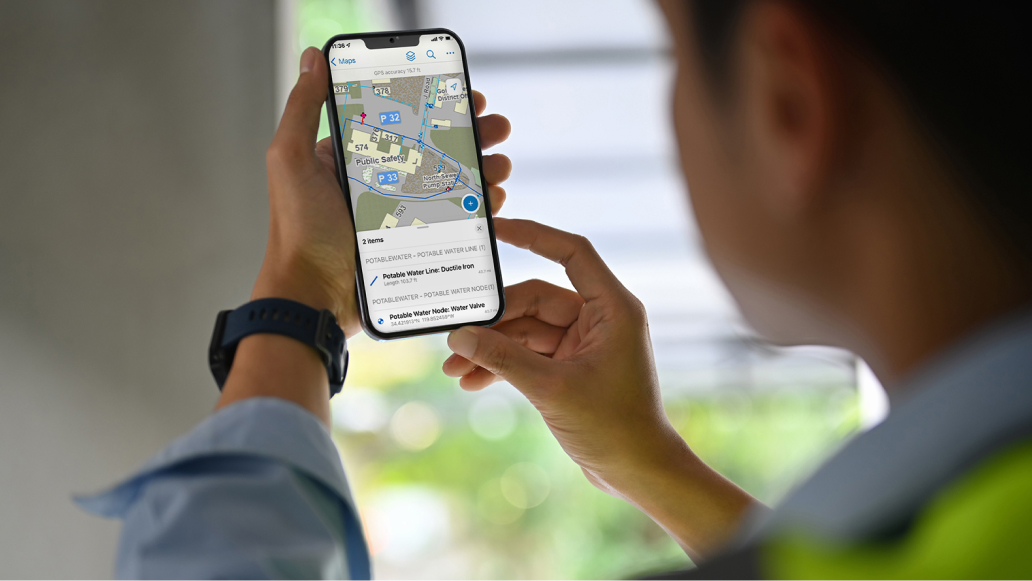 A person holds a smartphone displaying a digital map and navigation instructions. 