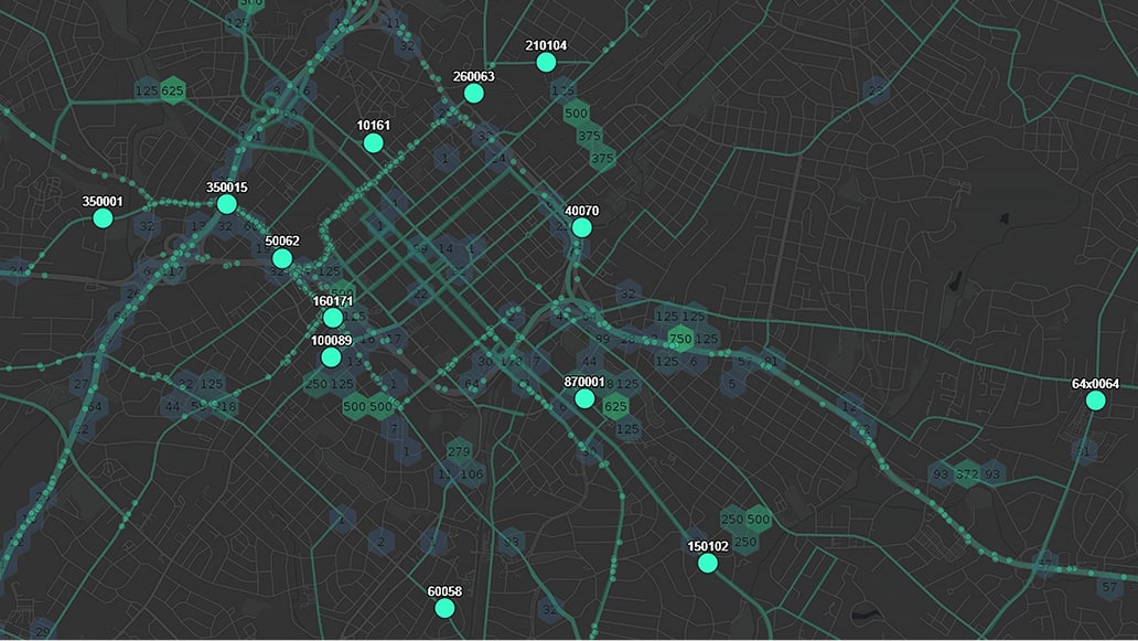 A dark-themed digital city map displays streets and neighborhoods overlaid with teal lines and circular data points