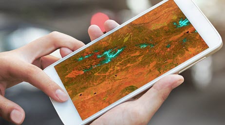 Two hands using a large smartphone with map on it 