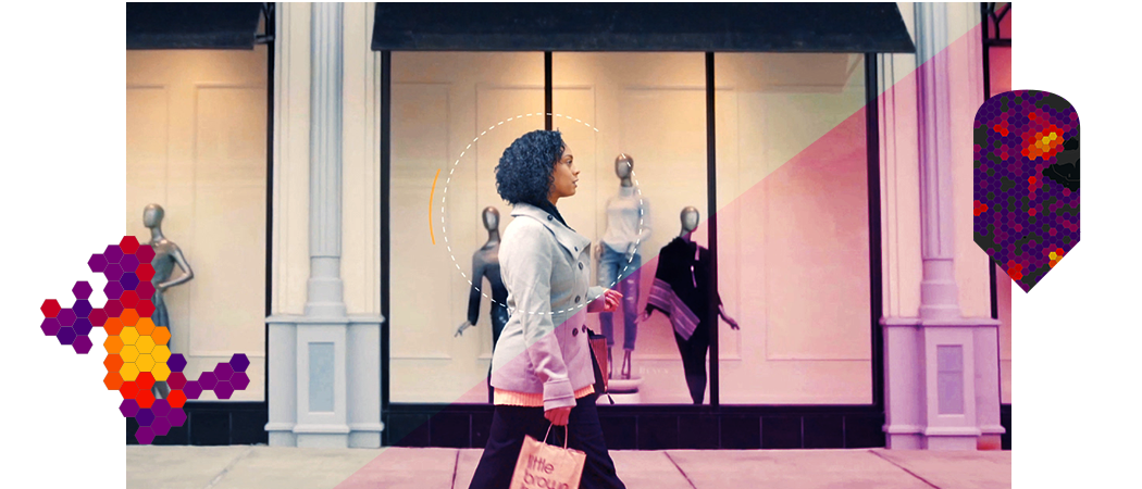 A person walking down a sidewalk in front of a clothing store