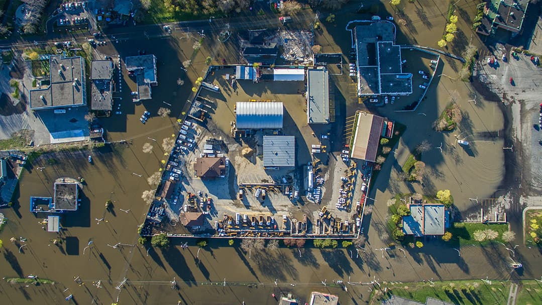 An aerial photograph capturing a flooded urban neighborhood surrounded by water.