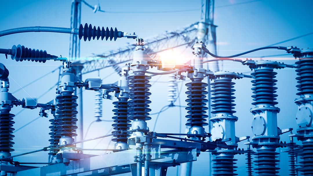 A close-up view of an electrical substation featuring high-voltage insulators and transformers.